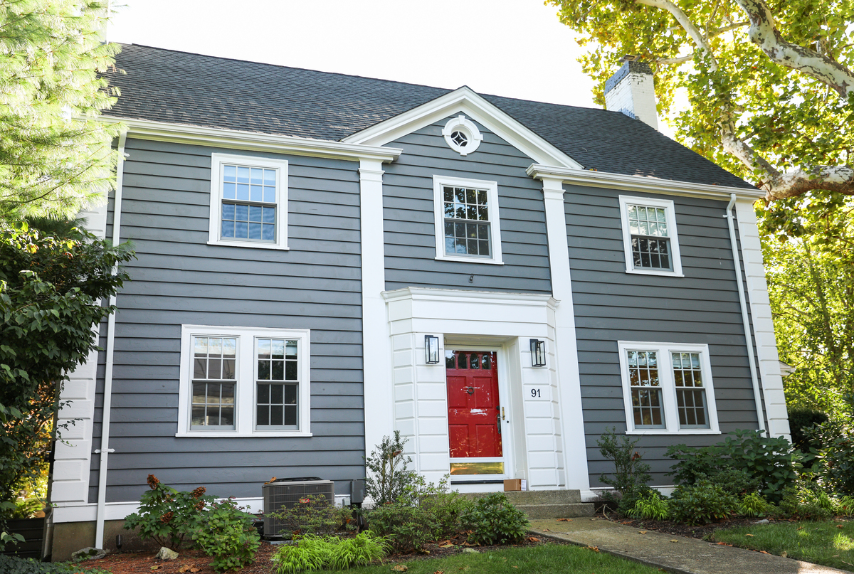 A two-story house undergoing a roof replacement.
