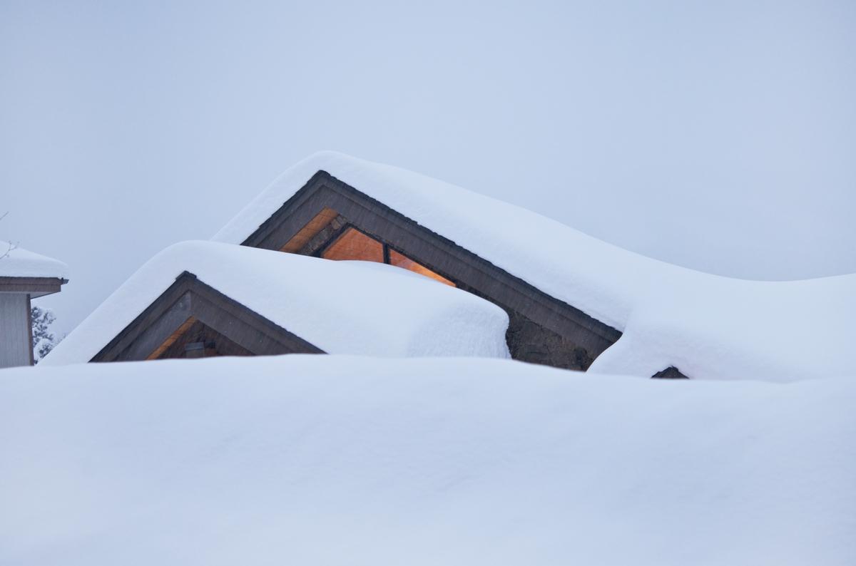 A blanket of snow on a roof with black fascia.