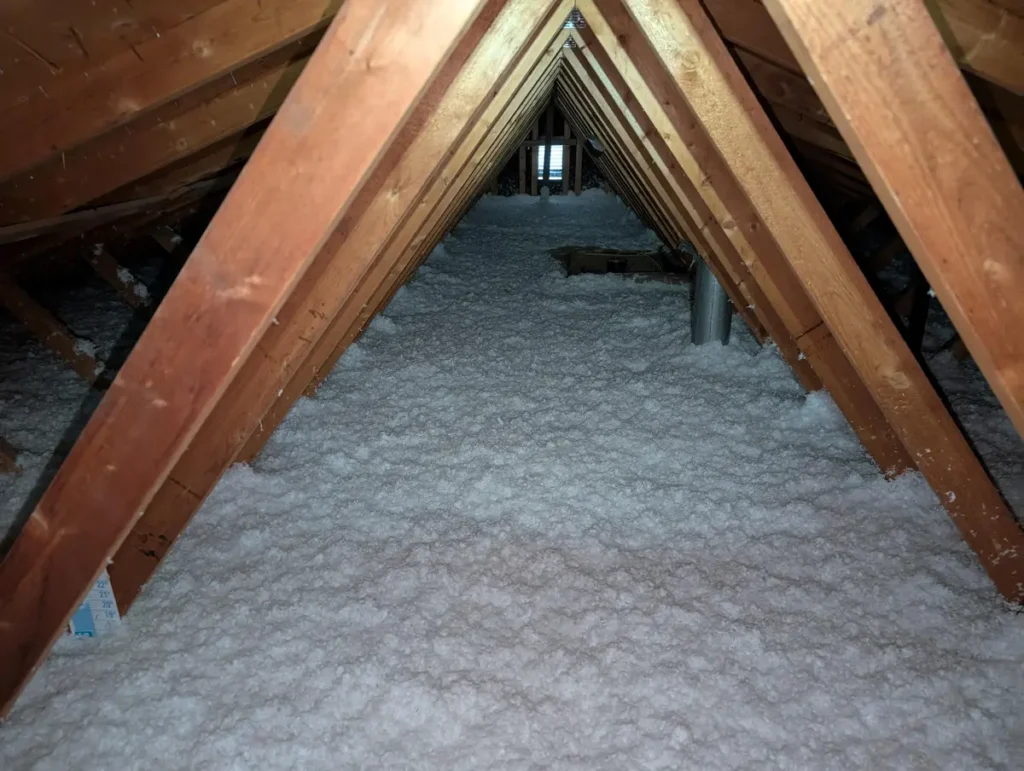 Blocked soffit vent packed with insulation beside a correctly installed rafter baffle