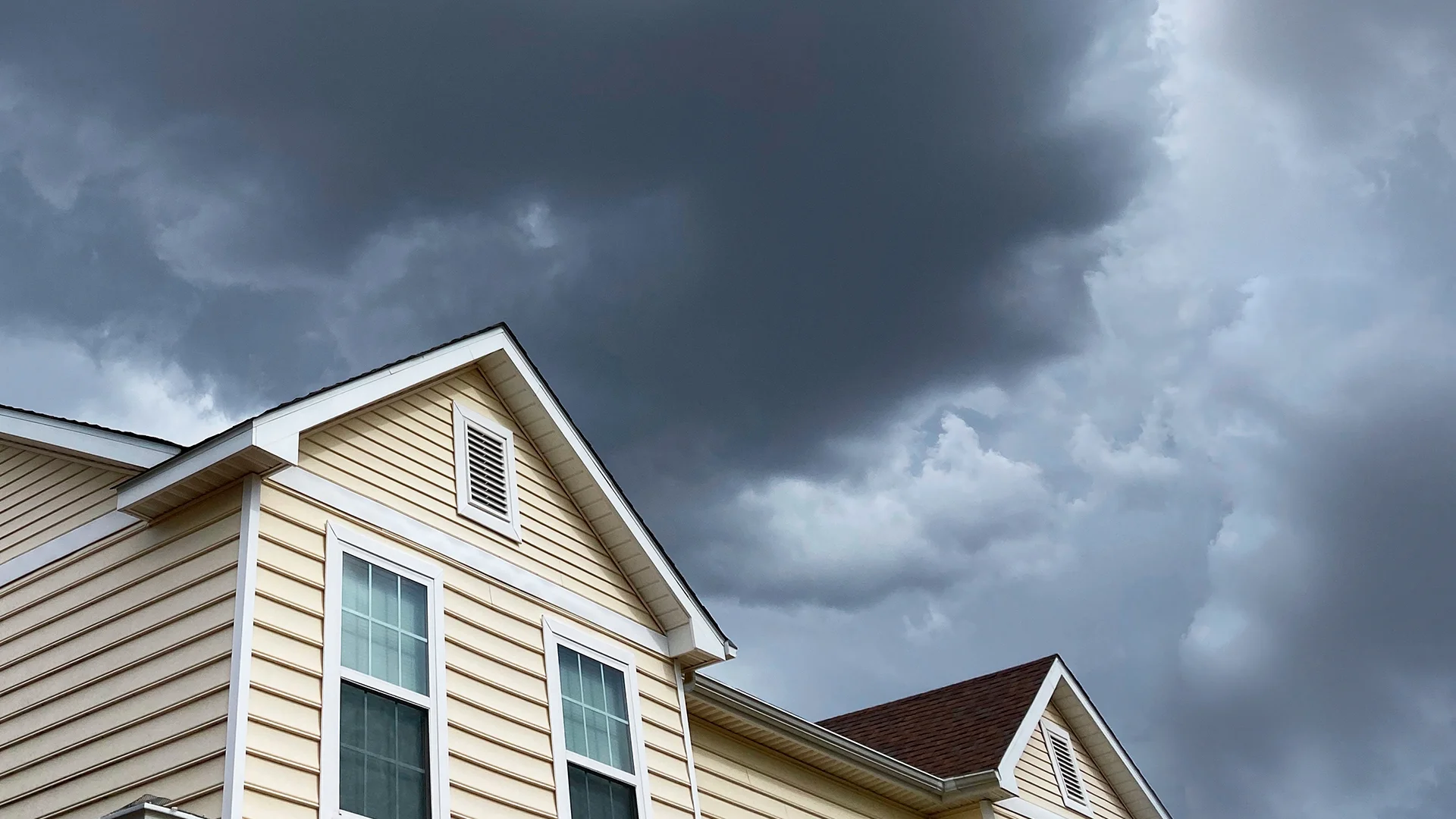 Massachusetts home roof under a stormy hurricane sky
