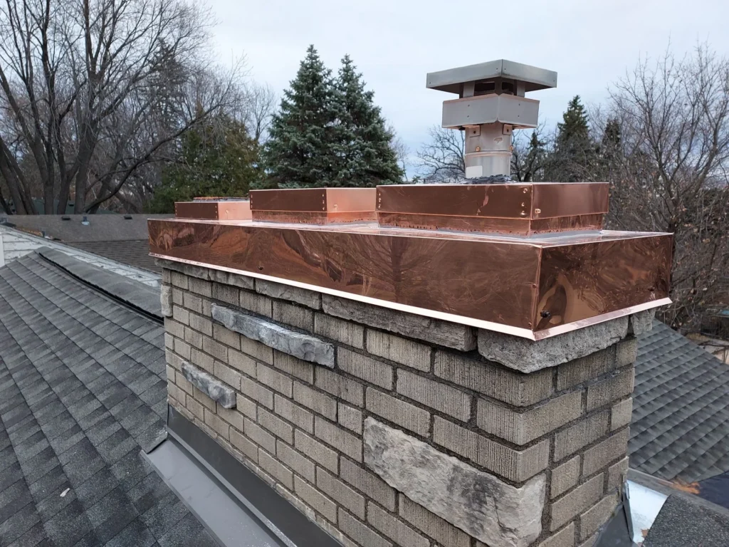 New metal chimney cap installed on a brick chimney