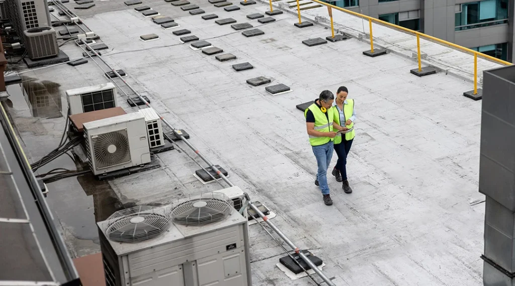 Technician inspecting commercial flat roof membrane seams