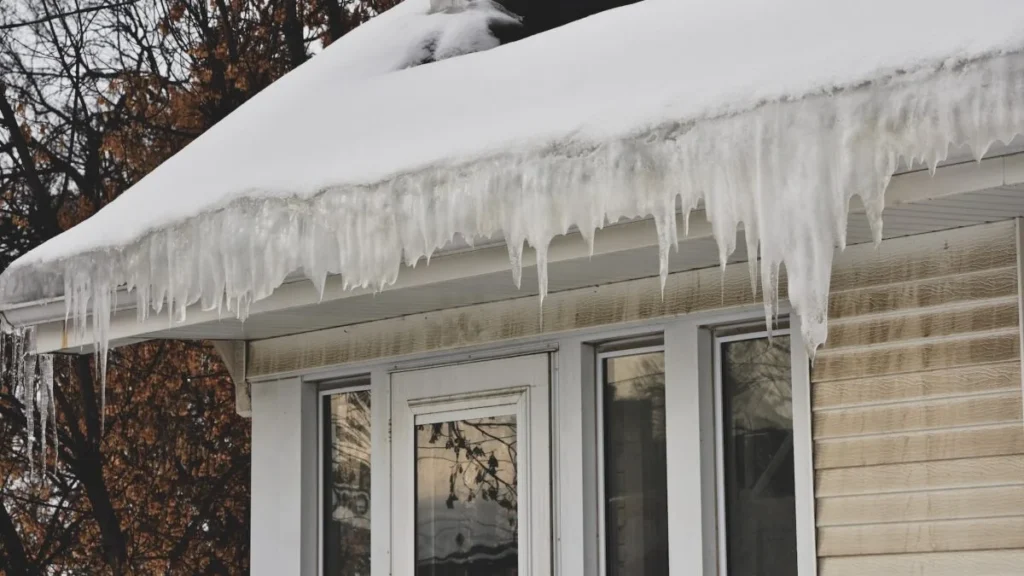 Massachusetts home with snow and ice buildup along roof eaves